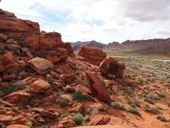 Rock formations on landscape against cloudy sky