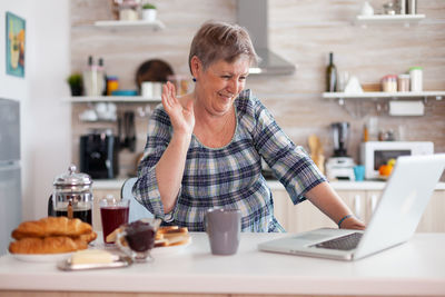 Young woman using mobile phone at table