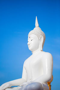 Low angle view of statue against blue background