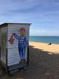 Lifeguard hut on beach against sky