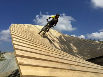 Low angle view of man riding motorcycle against sky