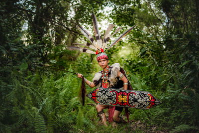 Low angle view of woman standing in forest