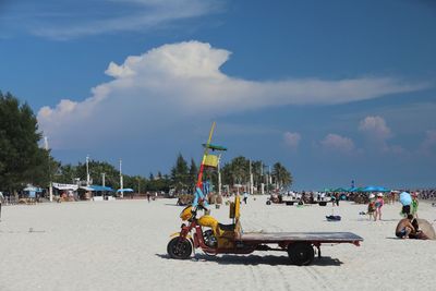 Panoramic view of people on beach against sky