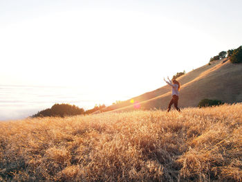 Woman standing on field against sky