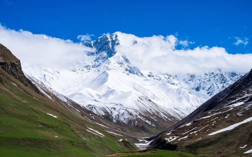 Scenic view of mountains against cloudy sky