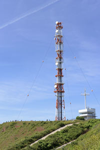 Low angle view of communications tower against blue sky