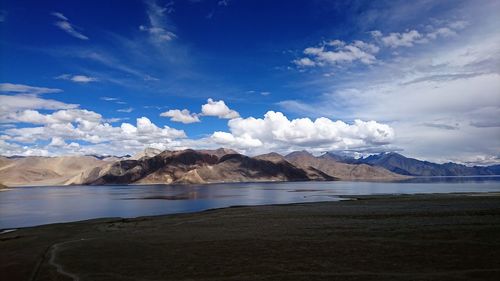 Scenic view of sea and mountains against sky