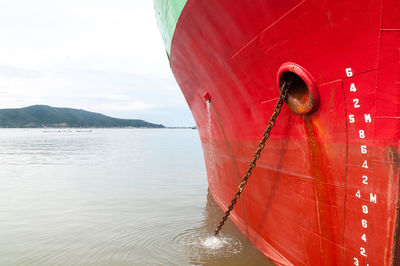 Close-up of boat sailing on sea against sky