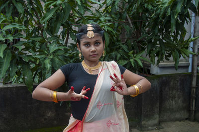 A teenage girl practicing bharatnatyam in nature