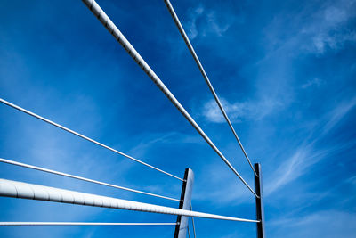 Low angle view of power lines against blue sky