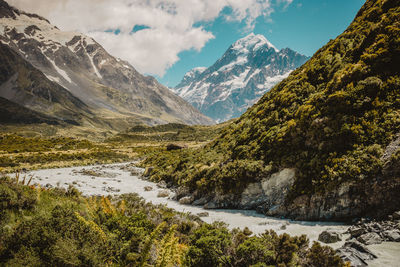 Scenic view of river amidst mountains against sky