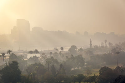 Panoramic shot of cityscape against sky during sunset