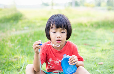 Portrait of boy sitting on grass