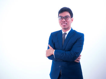 Portrait of young man standing against white background