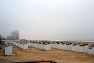 Huts at beach against sky