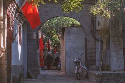 People on footpath amidst buildings in city