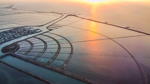Power lines against sky during sunset