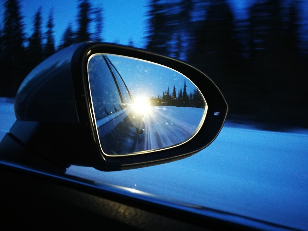 CLOSE-UP OF SIDE-VIEW MIRROR AGAINST CLEAR SKY