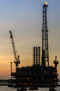 Oil production platform during sunset at offshore oil field