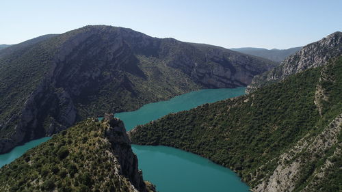 Scenic view of lake by mountains against clear sky