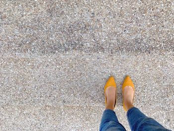 Low section of woman standing on footpath