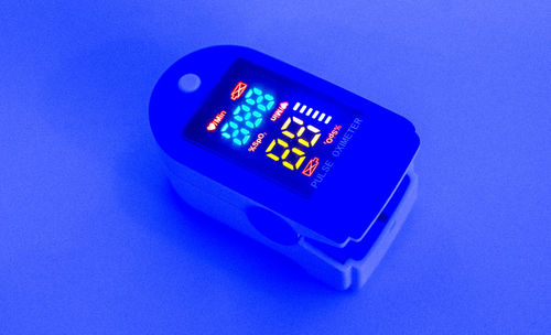 High angle view of illuminated clock on blue background