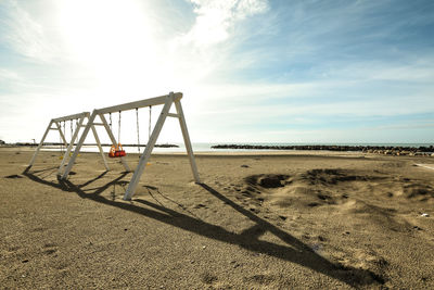 Playground on beach against sky