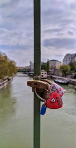 Close-up of padlocks on railing against river