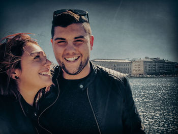 Portrait of smiling young couple in city