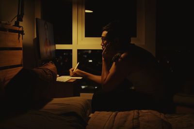 Rear view of woman sitting at home