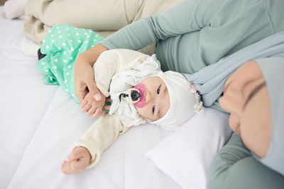 Baby and mother at home in bed, happy loving family