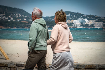 Rear view of men looking at sea