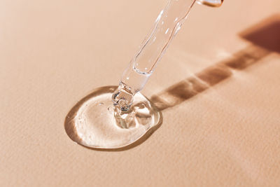 Transparent cosmetic gel with bubbles on a beige background close-up. hyaluronic acid for skin