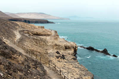 Scenic view of sea and mountains against sky