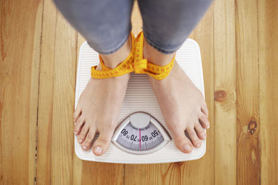 Low section of person standing on hardwood floor