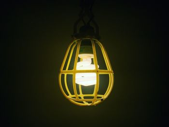 Close-up of illuminated electric lamp against black background