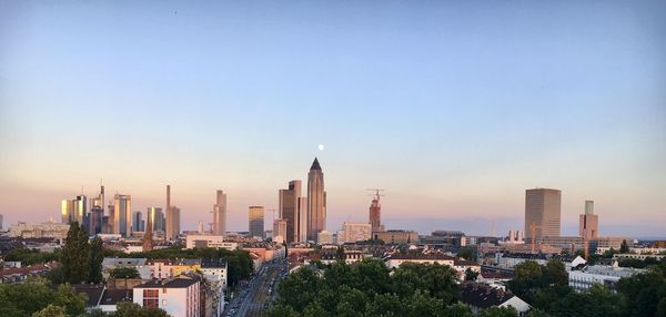 Buildings in city against sky during sunset