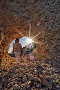 Rear view of woman standing in tunnel