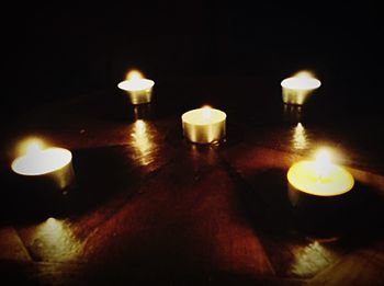 Lit candle in dark room