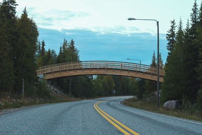 Road by bridge against sky