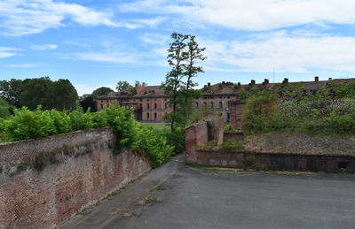 Footpath by old building against sky