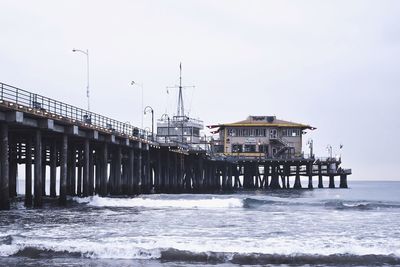 Pier over sea against sky during winter