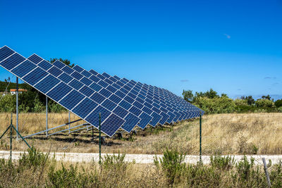 Solar panels on field against clear sky