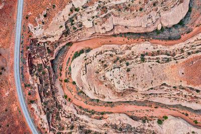 Top down drone photo of highway in utah through red canyon and empty riverbed