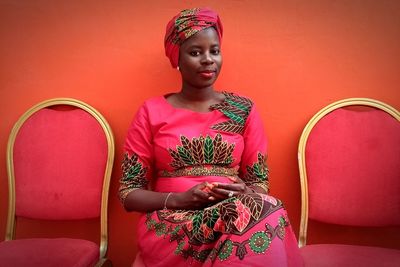 Portrait of woman in traditional clothing while sitting against wall