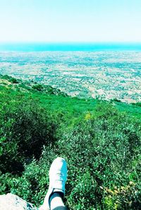 Low section of person on landscape against sky