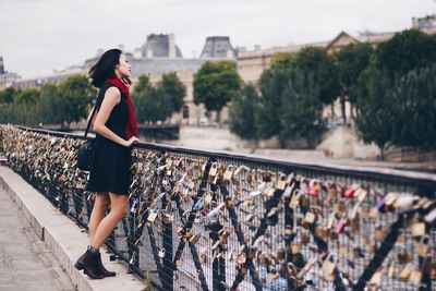 Woman with umbrella on bridge in city