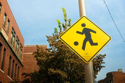 Low angle view of road sign against sky