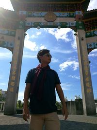 Low angle view of young man standing against sky