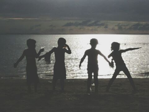 SILHOUETTE CHILDREN STANDING ON BEACH